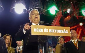 Viktor Orbán in front of a banner saying "Peace and Security"